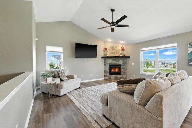 1143 Juniper Ln, Oconomowoc, WI 53066 - living area with vaulted ceiling, wood finished floors, a ceiling fan, and a stone fireplace