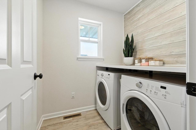 1143 Juniper Ln, Oconomowoc, WI 53066 - laundry area with separate washer and dryer, light wood finished floors, and wooden walls