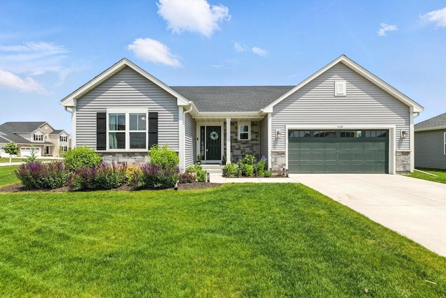 1143 Juniper Ln, Oconomowoc, WI 53066 - single story home with stone siding, an attached garage, a front yard, and concrete driveway