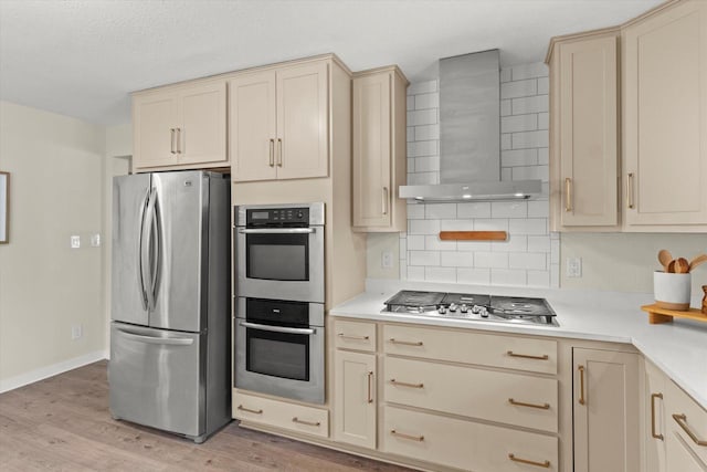 5717 S 42nd St, Greenfield, WI 53221 - kitchen featuring appliances with stainless steel finishes, wall chimney exhaust hood, cream cabinets, and light countertops