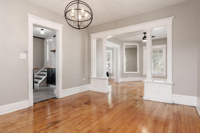 716 Vernon Ave, Beloit, WI 53511 - unfurnished dining area featuring ornate columns, light wood-style flooring, ceiling fan, and a chandelier