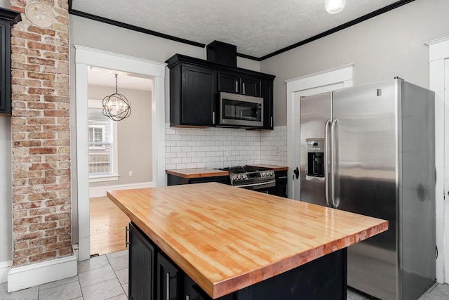 716 Vernon Ave, Beloit, WI 53511 - kitchen with wooden counters, stainless steel appliances, dark cabinets, backsplash, and a chandelier