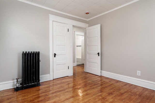 716 Vernon Ave, Beloit, WI 53511 - empty room featuring radiator heating unit, light wood finished floors, and crown molding