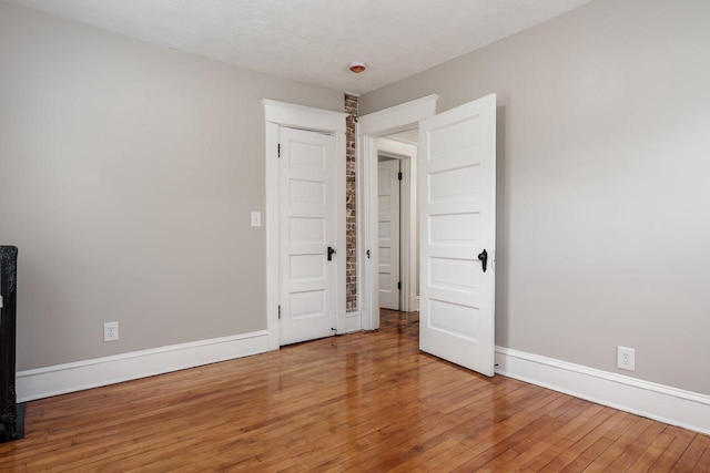 716 Vernon Ave, Beloit, WI 53511 - unfurnished bedroom with baseboards and hardwood / wood-style floors