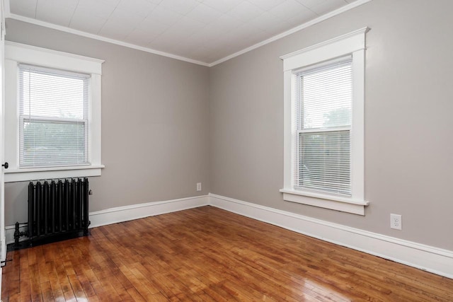 716 Vernon Ave, Beloit, WI 53511 - spare room featuring radiator heating unit, crown molding, plenty of natural light, and hardwood / wood-style flooring