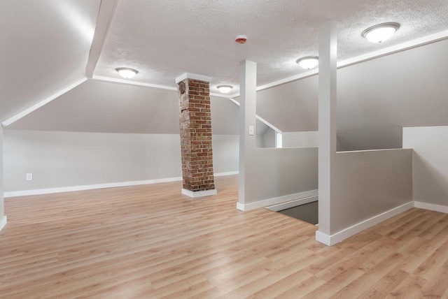 716 Vernon Ave, Beloit, WI 53511 - additional living space featuring vaulted ceiling, a textured ceiling, wood finished floors, and decorative columns