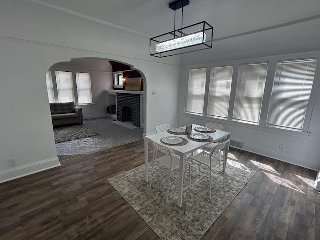 3041 N 52nd St, Milwaukee, WI 53210 - dining space featuring arched walkways, a brick fireplace, and dark wood-style floors