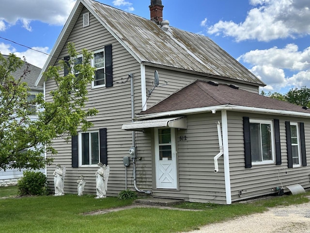512 Division St, Stoddard, WI 54658 - view of front of home with a chimney, a front yard, and a metal roof