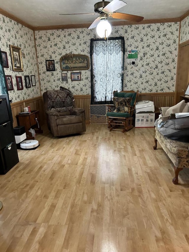 512 Division St, Stoddard, WI 54658 - sitting room with wallpapered walls, a ceiling fan, wainscoting, light wood finished floors, and crown molding