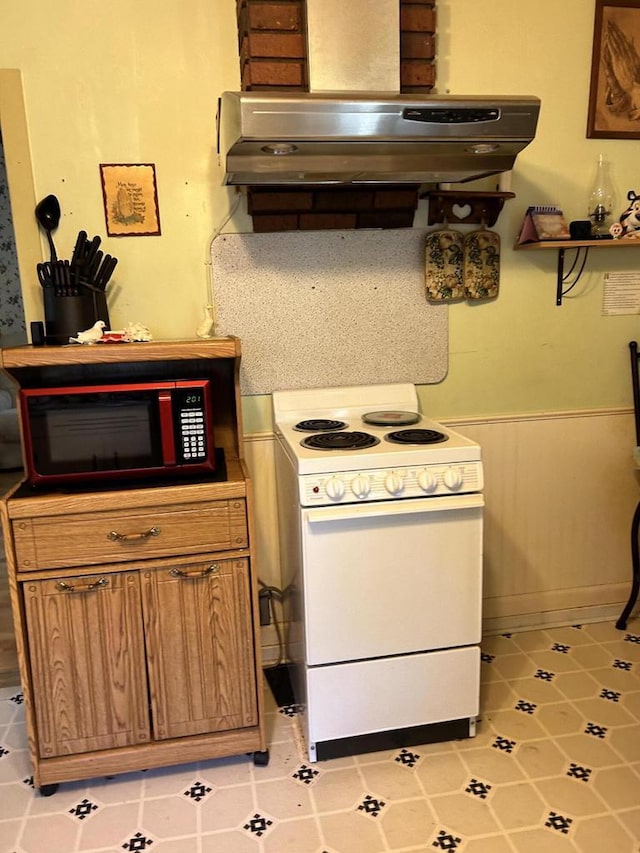 512 Division St, Stoddard, WI 54658 - kitchen with white range with electric stovetop, ventilation hood, a wainscoted wall, tile patterned flooring, and brown cabinetry
