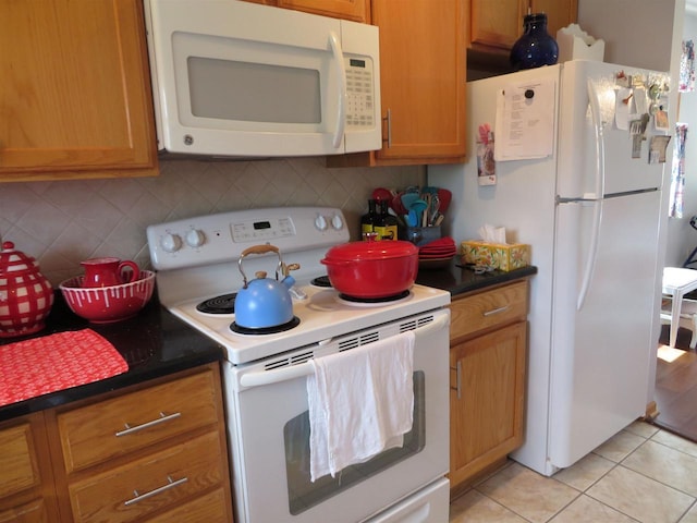 306 N Sales St Unit # 1, Merrill, WI 54452 - kitchen featuring white appliances, tasteful backsplash, dark countertops, and light tile patterned flooring