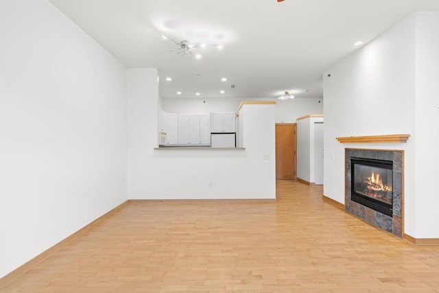 530 W Doty St Unit 107, Madison, WI 53703 - unfurnished living room with light wood finished floors, recessed lighting, and a tile fireplace