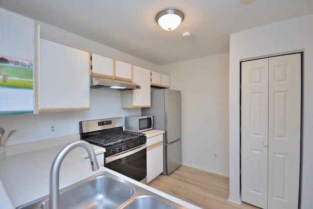 W192S7850 Overlook Bay Rd Unit 3, Muskego, WI 53150 - kitchen featuring stainless steel appliances, under cabinet range hood, light wood finished floors, light countertops, and white cabinets