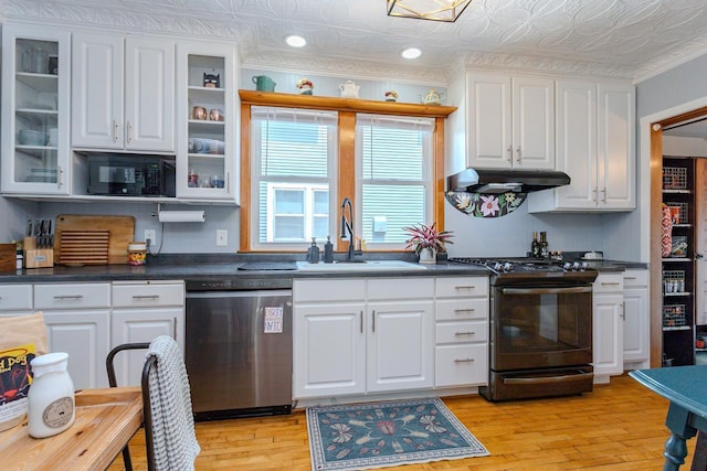 1756 Church St, Stevens Point, WI 54481 - kitchen with stainless steel appliances, under cabinet range hood, white cabinets, light wood-style flooring, and dark countertops
