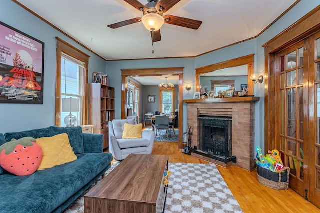 1756 Church St, Stevens Point, WI 54481 - living room featuring a ceiling fan, wood finished floors, crown molding, a fireplace, and a chandelier