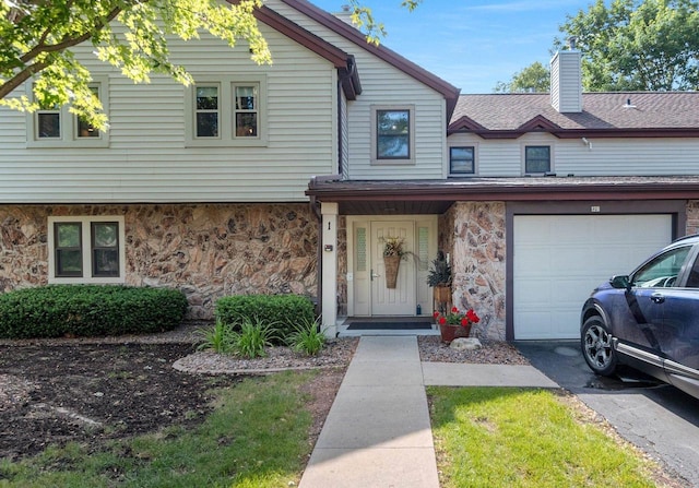 1820 Ridgeway Dr Unit 12A, De Pere, WI 54115 - townhome / multi-family property with stone siding, a chimney, a shingled roof, asphalt driveway, and an attached garage