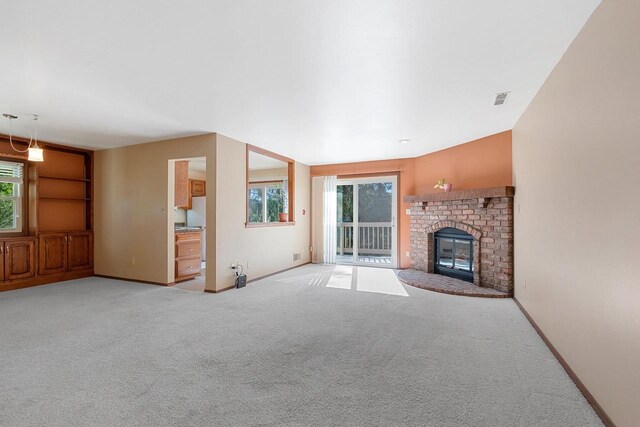 1820 Ridgeway Dr Unit 12A, De Pere, WI 54115 - unfurnished living room featuring light carpet, healthy amount of natural light, and a brick fireplace