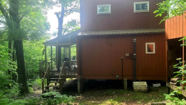 W4799 Rocky Hill Dr, Pembine, WI 54156 - view of property exterior featuring a sunroom, stairs, a wooden deck, and a metal roof