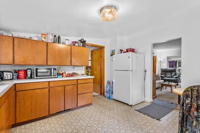 W914 Madsen Rd, Marinette, WI 54143 - kitchen with freestanding refrigerator, stainless steel microwave, light countertops, and brown cabinets
