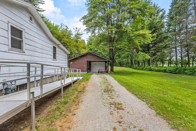 W914 Madsen Rd, Marinette, WI 54143 - view of grassy yard with dirt driveway, a detached garage, and an outbuilding