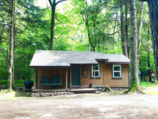 W15036 Poachers Run Ln, Athelstane, WI 54101 - view of front facade featuring a porch, roof with shingles, and a forest view