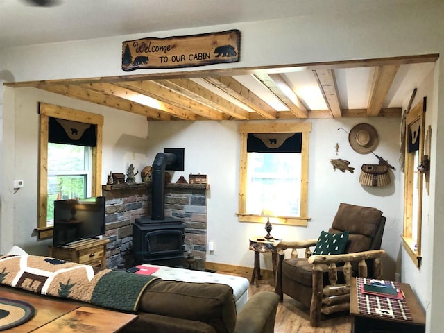 W15036 Poachers Run Ln, Athelstane, WI 54101 - living area featuring a wood stove, beamed ceiling, and wood finished floors