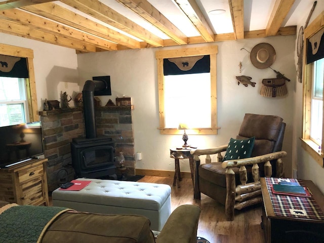 W15036 Poachers Run Ln, Athelstane, WI 54101 - living room featuring healthy amount of natural light, wood finished floors, beamed ceiling, and a wood stove