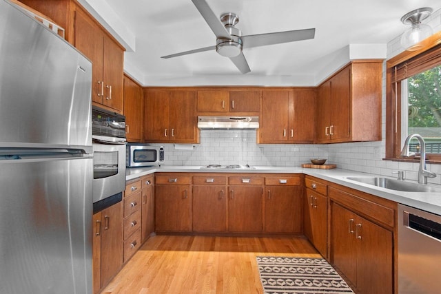 625 N Winnebago St, De Pere, WI 54115 - kitchen with stainless steel appliances, light wood-style flooring, under cabinet range hood, and brown cabinetry