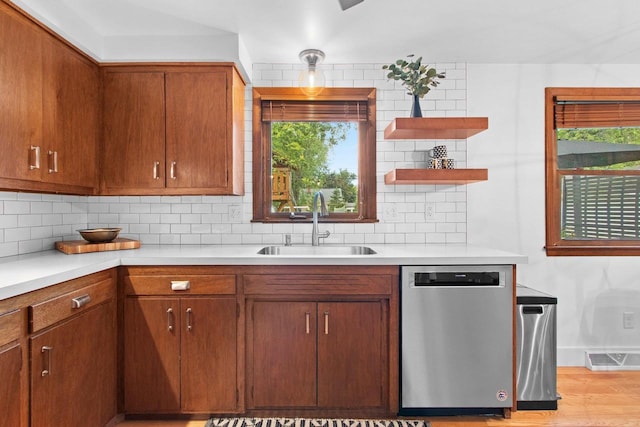 625 N Winnebago St, De Pere, WI 54115 - kitchen featuring stainless steel dishwasher, light countertops, tasteful backsplash, and brown cabinetry