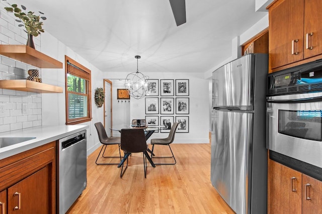 625 N Winnebago St, De Pere, WI 54115 - kitchen with stainless steel appliances, brown cabinets, light wood-style flooring, and decorative backsplash