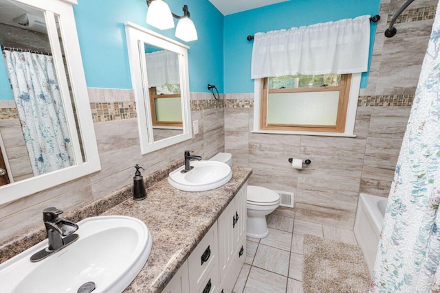 8383 N 50th St, Brown Deer, WI 53223 - bathroom with tile walls, double vanity, tile patterned floors, shower / bath combo, and wainscoting