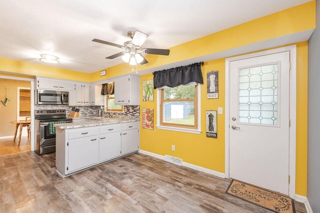 8383 N 50th St, Brown Deer, WI 53223 - kitchen with stainless steel appliances, light countertops, light wood-style flooring, a ceiling fan, and a peninsula