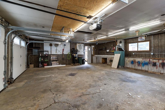 6610 Kelly Ln, Winneconne, WI 54986 - garage featuring a garage door opener, a workshop area, and wooden walls