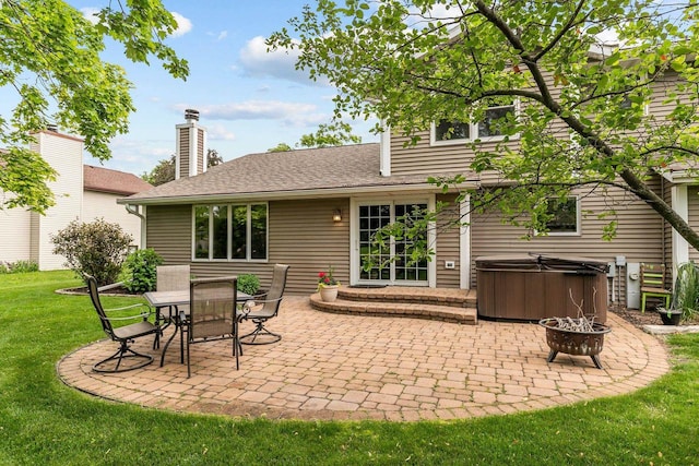 2939 W Roselawn Dr, Appleton, WI 54914 - back of house with a hot tub, a patio, a yard, a shingled roof, and a chimney