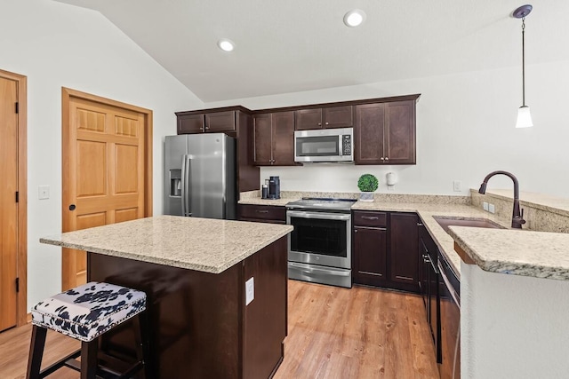1734 Arthurs Pass, Oconomowoc, WI 53066 - kitchen with stainless steel appliances, vaulted ceiling, dark brown cabinets, light wood finished floors, and decorative light fixtures