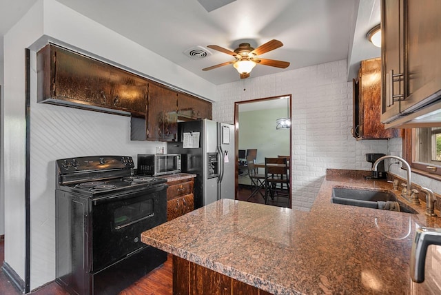 248 E Norport Dr, Port Washington, WI 53074 - kitchen featuring stainless steel appliances, ceiling fan, dark brown cabinetry, a peninsula, and dark wood-style floors