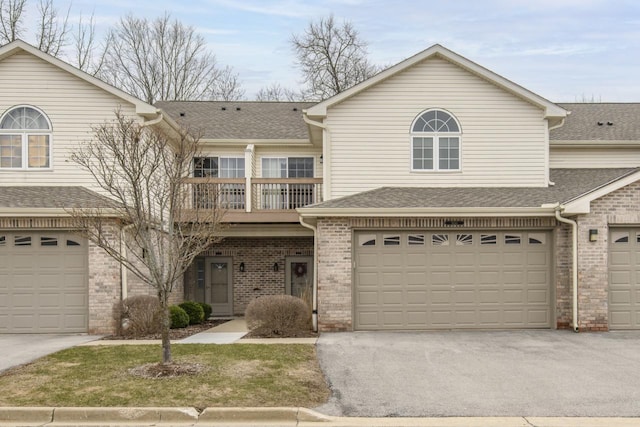 9245 S 54th St, Franklin, WI 53132 - view of front facade with brick siding, an attached garage, a balcony, and driveway