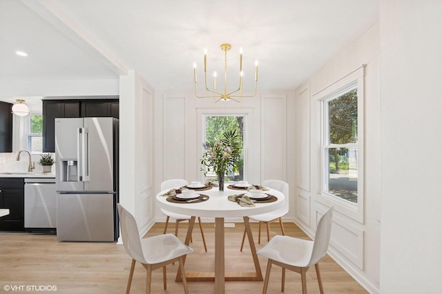 832 E Wilbur Ave, Milwaukee, WI 53207 - dining room featuring light wood-style floors, a chandelier, and a decorative wall