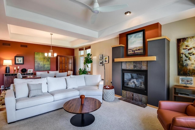 6846 Frank Lloyd Wright Ave, Middleton, WI 53562 - living room with a tray ceiling, carpet flooring, a chandelier, a tiled fireplace, and a ceiling fan
