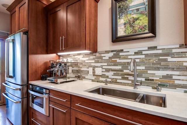 6846 Frank Lloyd Wright Ave, Middleton, WI 53562 - kitchen with stainless steel appliances, backsplash, and brown cabinetry