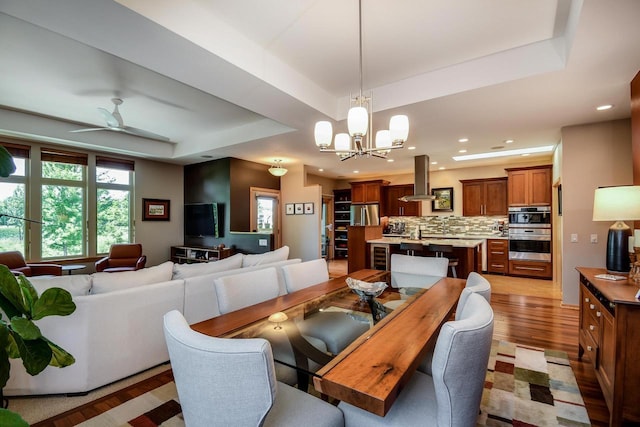 6846 Frank Lloyd Wright Ave, Middleton, WI 53562 - dining space with a raised ceiling, light wood-type flooring, a chandelier, recessed lighting, and ceiling fan