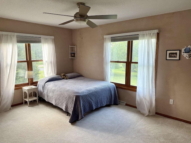 38630 Golf View Dr, Prairie Du Chien, WI 53821 - bedroom with light carpet, multiple windows, a ceiling fan, and a textured ceiling