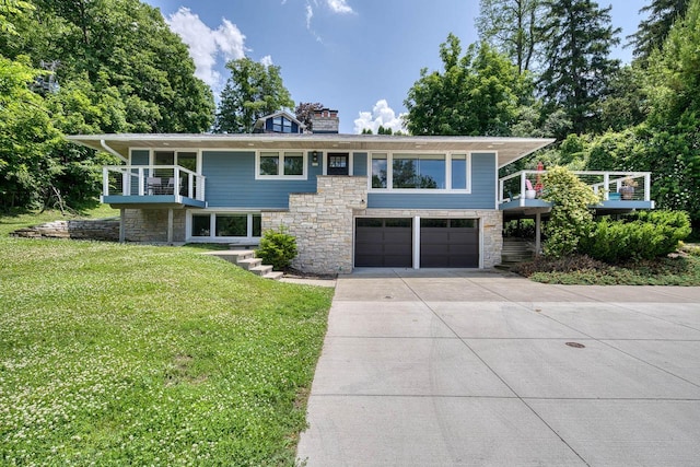 915 Mariane Ter, Lake Geneva, WI 53147 - view of front of property featuring an attached garage, concrete driveway, stone siding, a front lawn, and a chimney