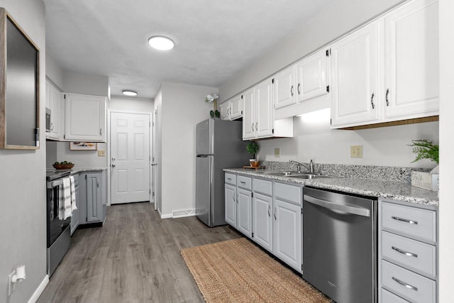102 Crab Apple Ct, Appleton, WI 54914 - kitchen with appliances with stainless steel finishes, white cabinets, wood finished floors, and light stone countertops