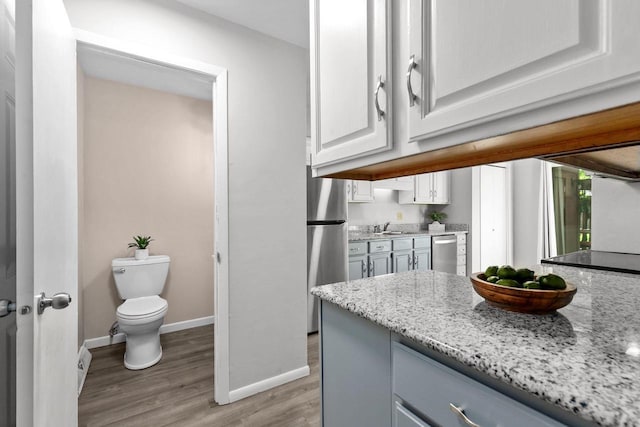 102 Crab Apple Ct, Appleton, WI 54914 - kitchen with appliances with stainless steel finishes, light wood-style flooring, light stone countertops, and white cabinets