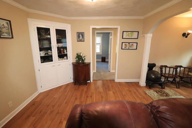 1503 St Lawrence Ave, Beloit, WI 53511 - living room featuring light wood-style floors, arched walkways, ornamental molding, and decorative columns