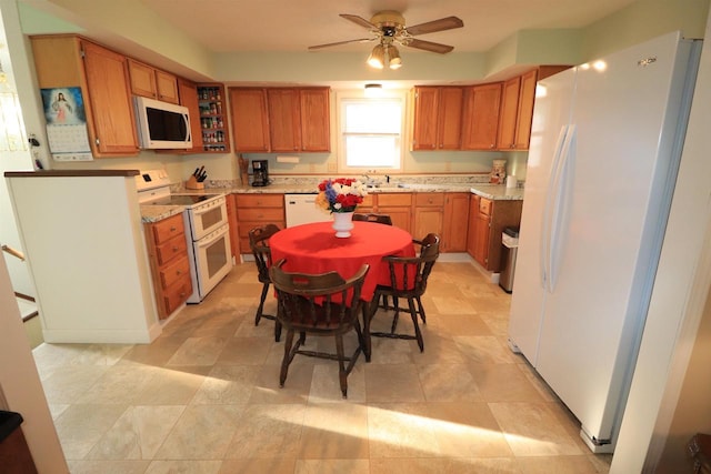 1503 St Lawrence Ave, Beloit, WI 53511 - kitchen featuring white appliances, ceiling fan, brown cabinetry, and light stone counters