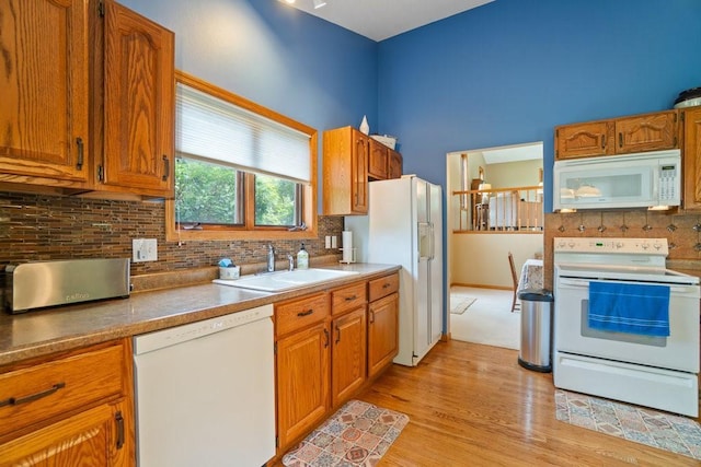 4129 Birch Crest Ln, Eau Claire, WI 54701 - kitchen featuring white appliances, tasteful backsplash, light wood-type flooring, and brown cabinets