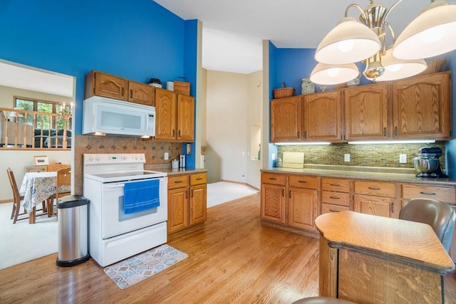 4129 Birch Crest Ln, Eau Claire, WI 54701 - kitchen with white appliances, tasteful backsplash, light wood finished floors, and brown cabinets