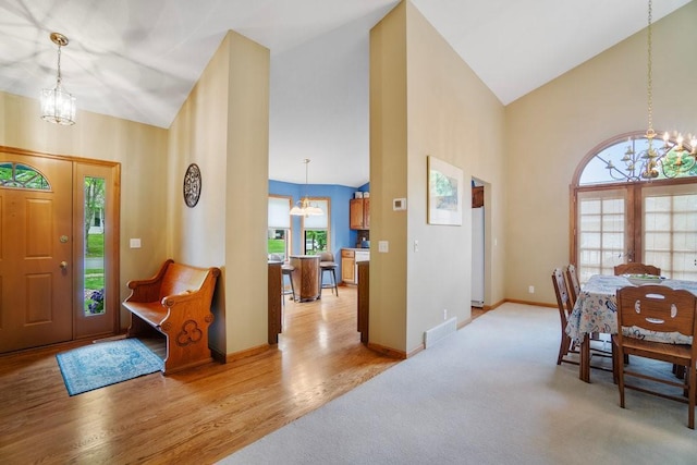 4129 Birch Crest Ln, Eau Claire, WI 54701 - entrance foyer featuring a chandelier, high vaulted ceiling, light wood finished floors, and light carpet